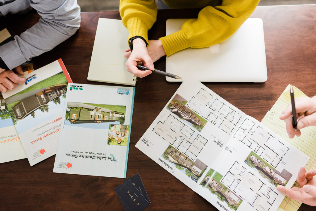 the countryside modular home team looks through plans while helping a customer through the buying process